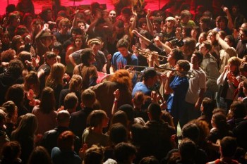 BDA : la musique d’abord, le reste… Trois lettres géantes pour seul décor : BDA, pour Boulevard Des Airs ? Désert, non. Ni dans la salle, pleine comme un œuf, ni sur scène qu’ils sont huit musiciens à se partager. Musiciens (excellents musiciens !) et non chanteurs, même s’ils chantent, un peu. Des mots, des vers ruisselant de bons sentiments, rien de bien exaltant, style « Je cours et c’est le temps qui se taille… » Bof ! C’est fade mais ne mange pas de pain, ça ruisselle de bons sentiments, un groupe engagé, de gôche il va sans dire. Constatant notre pays tel qu’il est, ils se fendent d’un refrain mille fois ressassé : « Oh France, je ne t’aime plus. » Bon, jusque là, ça va encore. On peut tiquer par contre quand ils reprennent Le Chant des partisans qu’ils affadissent, appauvrissent, qu’ils mettent au rang de n’importe quel titre, chanté puis oublié sur l’instant. Le Chant des partisans est un sanctuaire dans lequel on ne peut entrer qu’avec talent, comme Léotard le fit naguère. Eux en font du rien et c’est un crime. Ils sont la bougeotte incarnée, à toujours sillonner la grande scène, qu’ils hantent de leurs notes cuivrées, de l’exubérance de leurs portées. Non, vraiment, Boulevard des airs est un groupe musical : qu’il le reste ! Dont on doit reconnaître la qualité même s’il peut profondément nous ennuyer.  Hier nous avons eu, en un seul plateau scénique, et le boulevard et la rue. Reconnaissons que la rue fut large et le boulevard étroit, étroit. VB & MK 