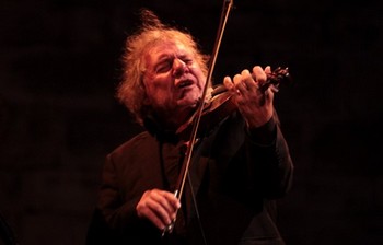TEICHER : Y'A D'LA JOIE ! Il est d'autres artistes qui, à leur manière, luttent contre l'oubli. L'oubli de pans entiers de la chanson d'expression française. A ce titre, le « fou chantant » n'a étonnamment que peu de repreneurs. Bien sûr les grands médias citeront Benjamin Biolay – ils n'ont que lui à l'oreille. Mais à deux de tension, peut-on restituer la fougue et le suc de l'auteur de Nationale 7 et de Je chante ? Dans la torpeur, dans la douce chaleur d'une soirée de Barjac, le belge Yves Teicher a réveillé le public, le dopant à je ne sais quel substance : de la joie sans doute, part prépondante à l'élixir de la jeunesse éternelle. Pas de chapeau mou ici pour singer Trenet mais le talent de lui rendre justice, de nous le restituer. Et un violon qui a trempé son archet dans pas mal de musiques. De quoi faire fête à la chanson tout en préparant, intéressante transition, au Brut de Brastch qui suivait et sur lequel nous reviendrons. (photo Catherine Cour)