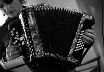 MAGALI FOURNIER, IMPERTINENTE ACCORDÉONISTE Magali, c’est la jolie surprise de la soirée. Cette chanteuse autodidacte, qui a repris la chanson, sa passion de jeunesse, avec l’accordéon découvert à 15 ans, après avoir élevé ses enfants, se produit en café concert sur la région. Elle figurait d’ailleurs dans la programmation de l’Off du Festival de chanson française d’Aix où je n’avais pu me rendre. Un petit bout de femme dans sa robe fleurie, plantée avec aplomb devant ce public impressionnant quand on a l’habitude des petits lieux. Elle continue la tradition des chanteuses des rues avec une voix claire est bien posée de petite fille, une personnalité rebelle bien affirmée, et écrit et compose ses chansons. Elle nous avoue être une mauvaise fille, une mauvaise graine; se met dans la peau de la voleuse qui cambriolé son appartement. Fait l’inventaire des hommes qui pourraient être l’élu, comme Arno le fait avec Lola, Carla, Elga, Olga ou Cinderella, sans trouver la perle rare. Chansons sur les relations amoureuses, la fête de vivre, neuf titres en tout. Et termine par une J’ai peur qui fait penser à celle de Leprest, bien que sur un rythme entraînant (elle y a peur du vide, du noir, de tout, de rien, de Marine, des pompiers, de vivre…mais n’a plus peur dans ses bras) De la génération de ces chanteuses alliant charme et caractère.