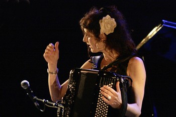 CHLOE LACAN TRIO. SOUS LES ETOILES EXACTEMENT   Retour de Chloé Lacan sur la grande scène de Barjac, après une première incursion au même endroit en 2012, en première partie de Romain Didier. Alors adepte des prestations en solitaire et de leurs plaisirs, elle nous avait montré, par des vocalises maîtrisées, l'étendue de la tessiture de sa voix et l'originalité de ses accompagnements en percussions corporelles, accordéon et ukulélé. Ses musiques au service d'une authentique écriture balayaient déjà le thème récurrent de l'amour, du désir, de la fidélité, voire de la jalousie. Elle nous revient en tête d'affiche : après un mois passé sous le plafond d'une petite salle, son spectacle d'Avignon prend de l'ampleur sous le ciel étoilé, et le volume sonore (réglé à la va-vite pendant l'entracte, les balances n'ayant pu se faire l'après-midi pour cause de pluie diluvienne) trouve de nouvelles dimensions. Le conducteur est globalement comparable, enrichi de quelques nouvelles chansons dans lesquelles les membres du trio peuvent laisser libre cours à la fantaisie de leurs multiples instruments. Ce spectacle fut donc plus éclaté et les six cents spectateurs et quelques chauves-souris de la cour du château ont bénéficié d'un patchwork de situations musicales diversifiées et d'artistes plus en capacité d'échange et de partage avec le public. C'est sans doute ce qu'ils retiendront : un ensemble de chansons aux sonorités originales et aux idées bien arrêtées, des artistes aux possibilités multiples et une Chloé Lacan épanouie et en empathie avec une salle dont le plafond touche aux confins de l'univers.   FRANCOIS BELLART